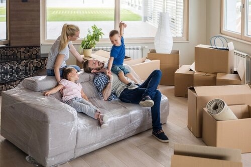 Happy Family Having Fun While Relaxing From Unpacking Their Belongings In New Apartment