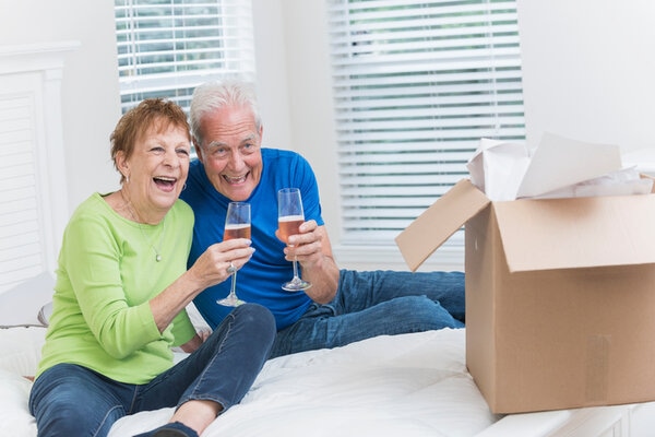 Senior Couple Moving House Celebrating With Champagne Senior Couple Moving House Celebrating With Champagne