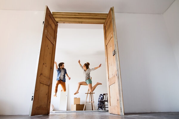 Young Couple Moving In A New House Jumping Up High Young Couple Moving In A New House Jumping Up High